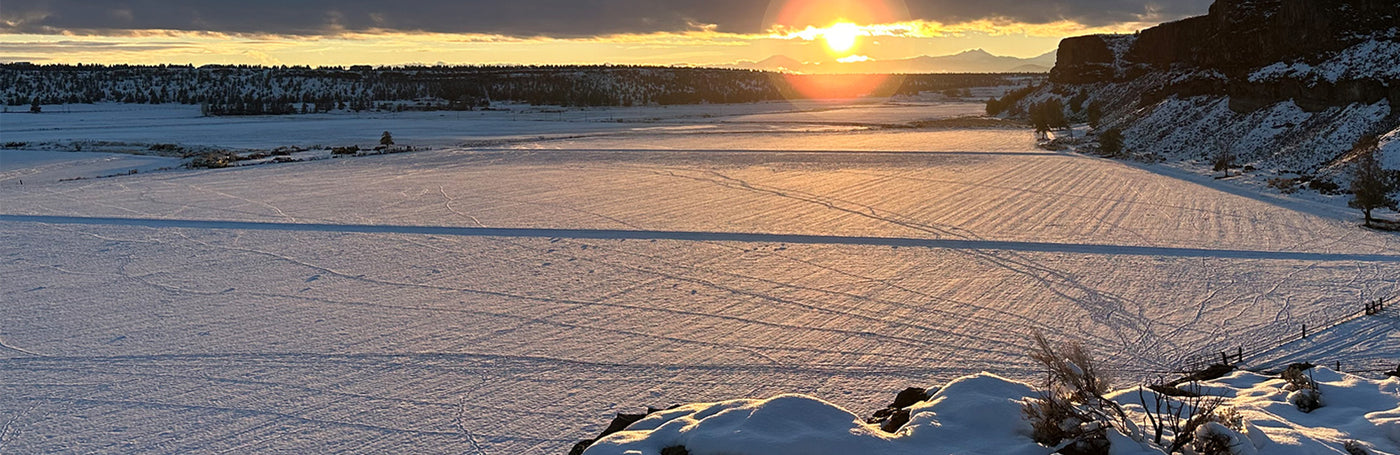 Sunset over a frozen field and a snow-covered landscape