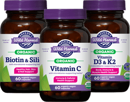 Woman holding a wooden bowl of salad in a kitchen